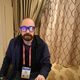 Me, sitting in a chair with a pair of blue glasses on my head.